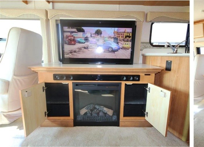 Custom RV media center with fireplace, storage cabinets, and a mounted flat-screen TV